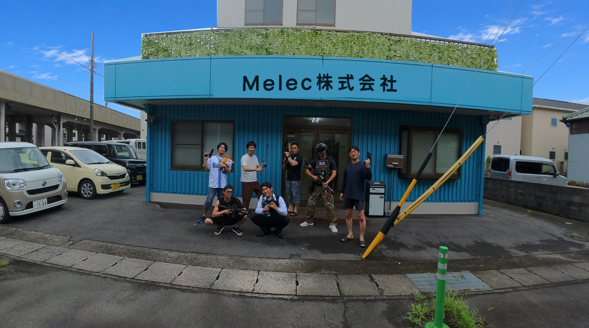 Melec株式会社の事務所前に集まるスタッフ